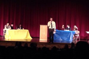 CHS teacher Mr. Naylor introduces the second round of debates to the audience assembled in the auditorium.