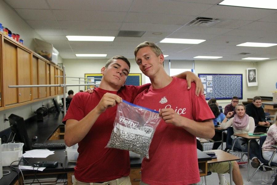 Jacob McCaulley and Nathan Davis present the bag of tabs Mrs. Flarend has already assembled for the tab drive.