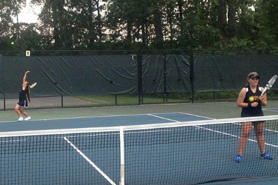 Tina Hollen serves as Hannah Klesius waits in the duos doubles victory against Huntingdon yesterday.