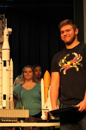 Sophomore Jack Showalter beside model rocket.