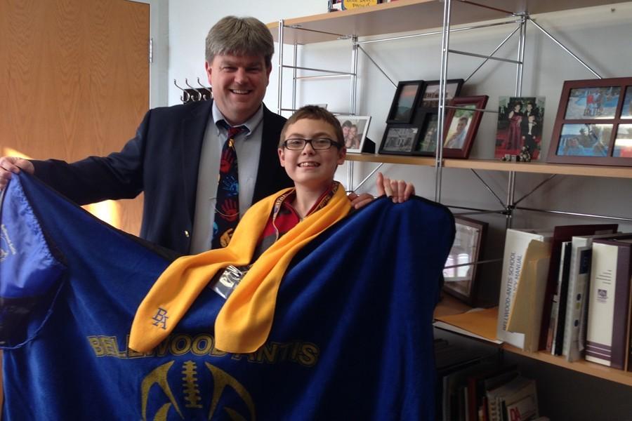 Sebastian Geyer receives his winnings from Dr. McInroy for the book tree contest in the district office.