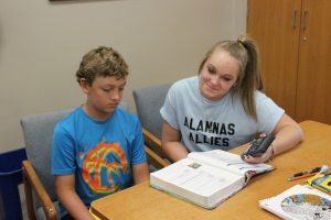 Junior Lexi Gerwert helps middle-schooler Mike Hostler with math.