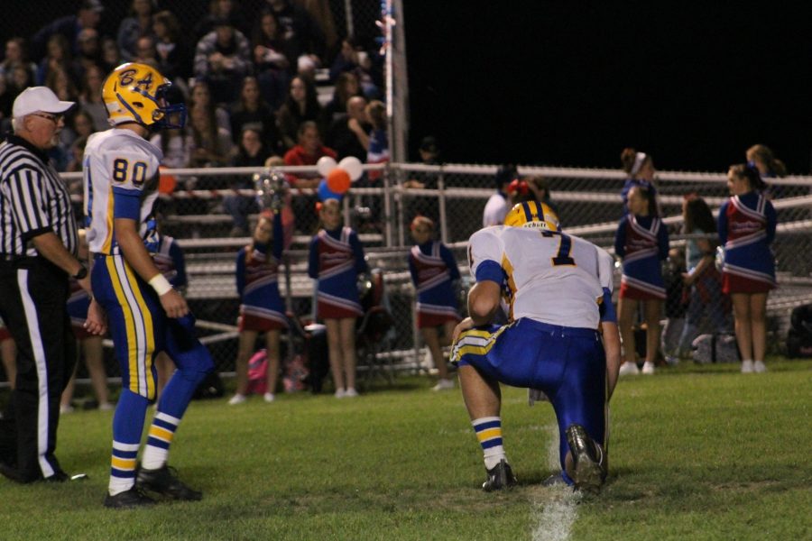 Brendan Kowalski sizes up a PAT as Jarrett Taneyhill prepares for the placement.