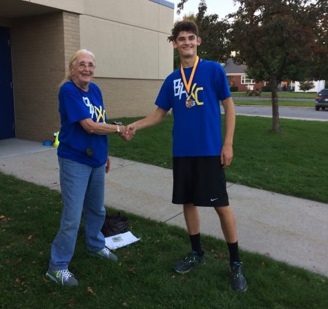 Junior Robert VanKirk is congratulated by Coach R after taking second at the ICC championship meet.