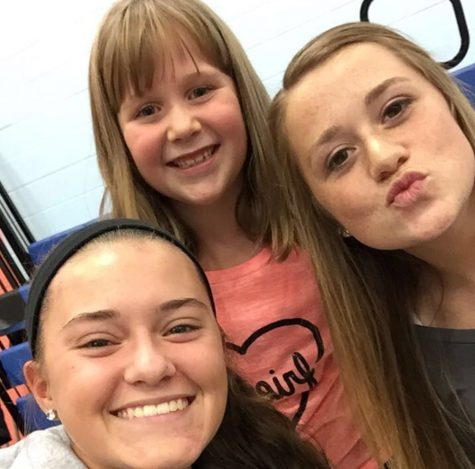 Volleyball seniors Abby Luensmann and Sophie Damiano took time for a selfie Wednesday with second grader Emma Taneyhill during the teams trip to Myers to build support for the program among the communitys young girls.