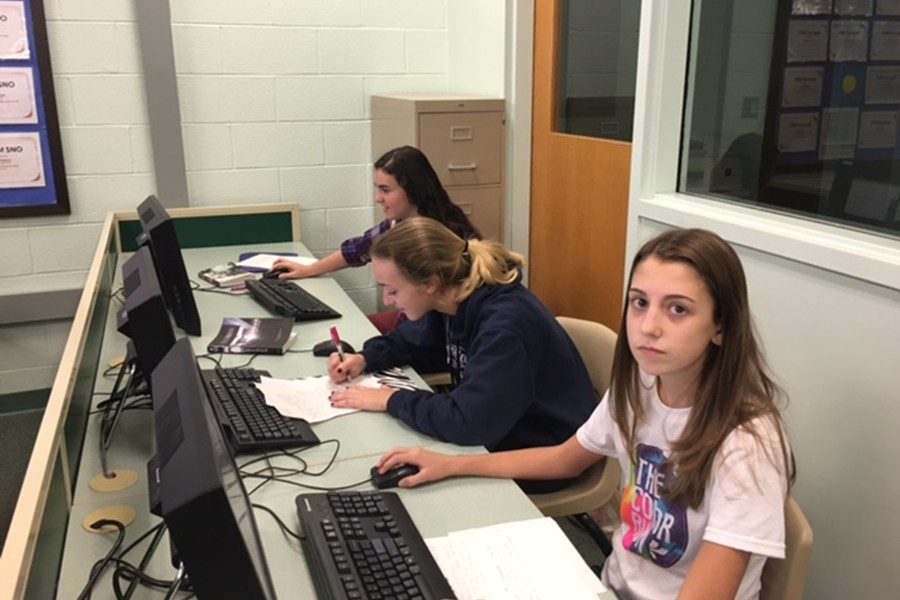 Emilee Leidig, Bennin Abbott and Emily Osborne work hard during eighth period. For them, the purpose was to finish an essay, but many students disagree on the purpose of education as a whole.