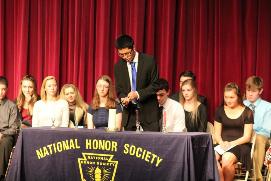 President Devon Zheng lights a candle at NHS inductions.