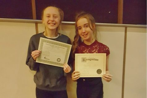 Jenna Bartlett and Haley Campbell display their certificates from the District speech championships. 