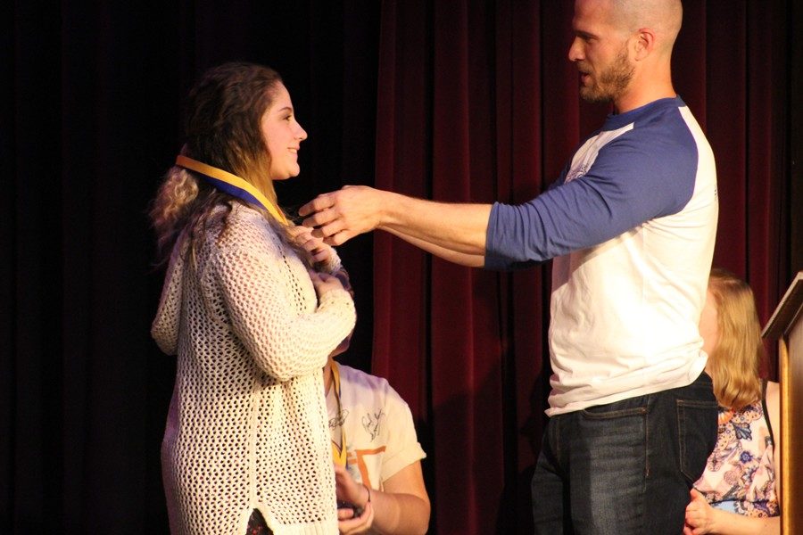 Isabella Barbosa receives her first place medal as the top overall slam poet at the 14th annual Poetry Slam.