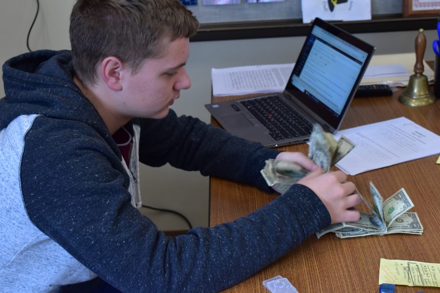 Freshman Class Secretary Dawson Miller counts money raised for a new freshman scholarship.