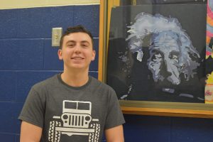 Lincoln Boyer poses with one of his paintings from art class.