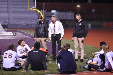 Soccer coach Alex Bartlett talks strategy with his team at halftime of the district 6 3A championship.