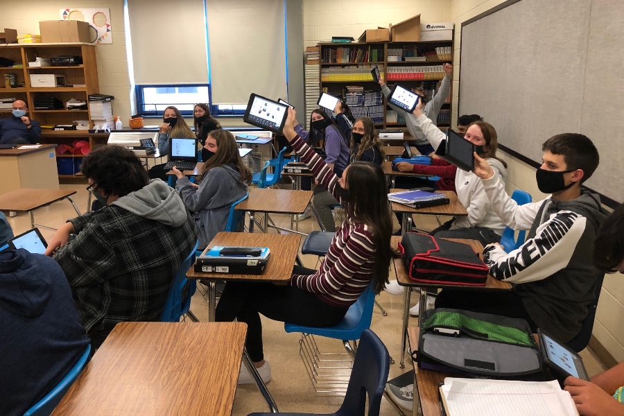 High school students back up their iPads in preparation for a possible move to virtual learning in the face of rising COVID numbers.