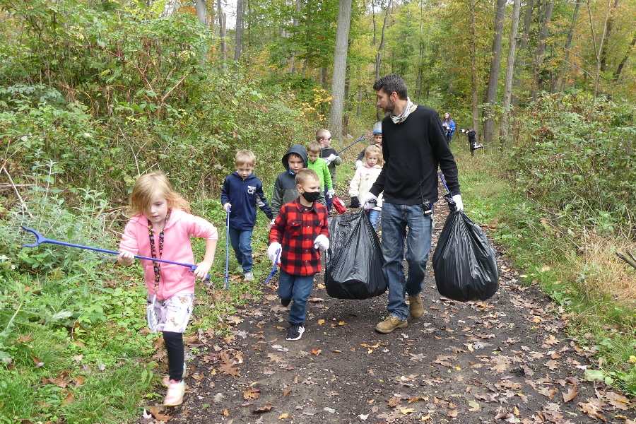 Myers teacher Mr. Dave Plummer and his students clean litter off a trail near the elementary school.