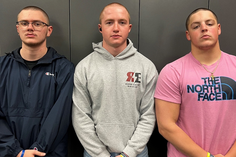 Tighe Eaken, Eli Pluebell, and Ethan Norris show off their freshly shaved domes.