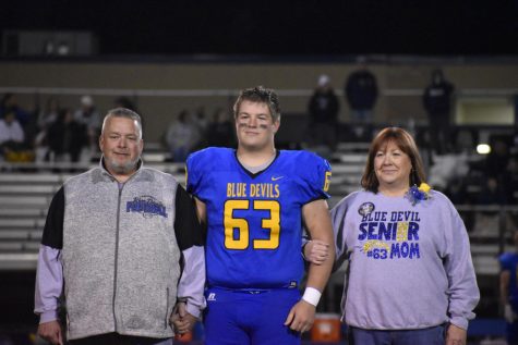 Andrew Nycum, shown with his father Jeff and mother Susan at football Senior Night, is coming back out for basketball this year.