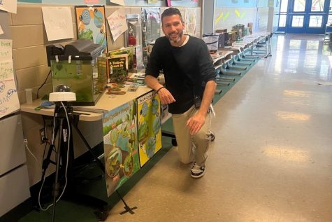 Mr. Plummer is livestreaming tadpoles in an aquarium outside of his room to teach students about the life cycle of frogs.