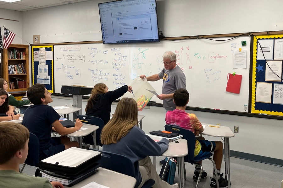 Mr. Partner hands out highlighters while starting a lesson on an Article of the Week.