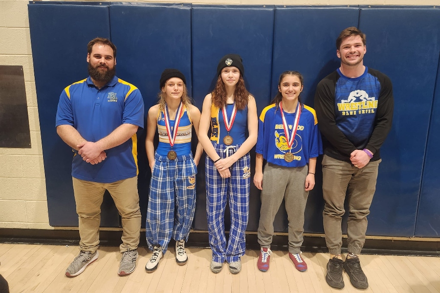 Wrestlers Hailey Loupe (L), Ellie Patterson (C) and Juliette Cuevas (R) each qualified for the central region wrestling tournament with top 6 finishes at the District 6 championships. Theyre pictured with coaches Trevor Helsey (L) and Nick Torsell (R).