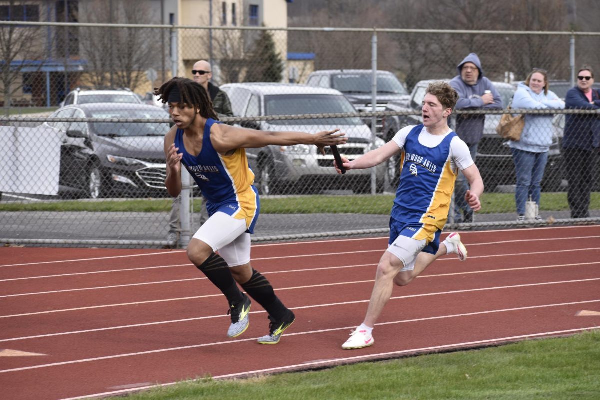 Colin Gibbons hand the baton off to Gabe Thompson during the 4x100m relay.