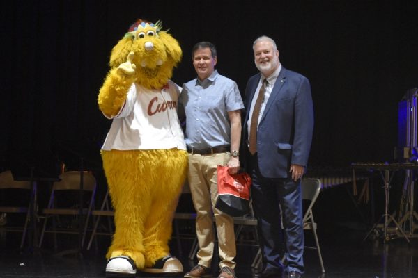 Mr. Rhone, accompanied by Curve mascot Loco and 1st Summit Bank Senior Vice President Ronald Yeager, receives prizes for being named Curve Teacher of the Year.