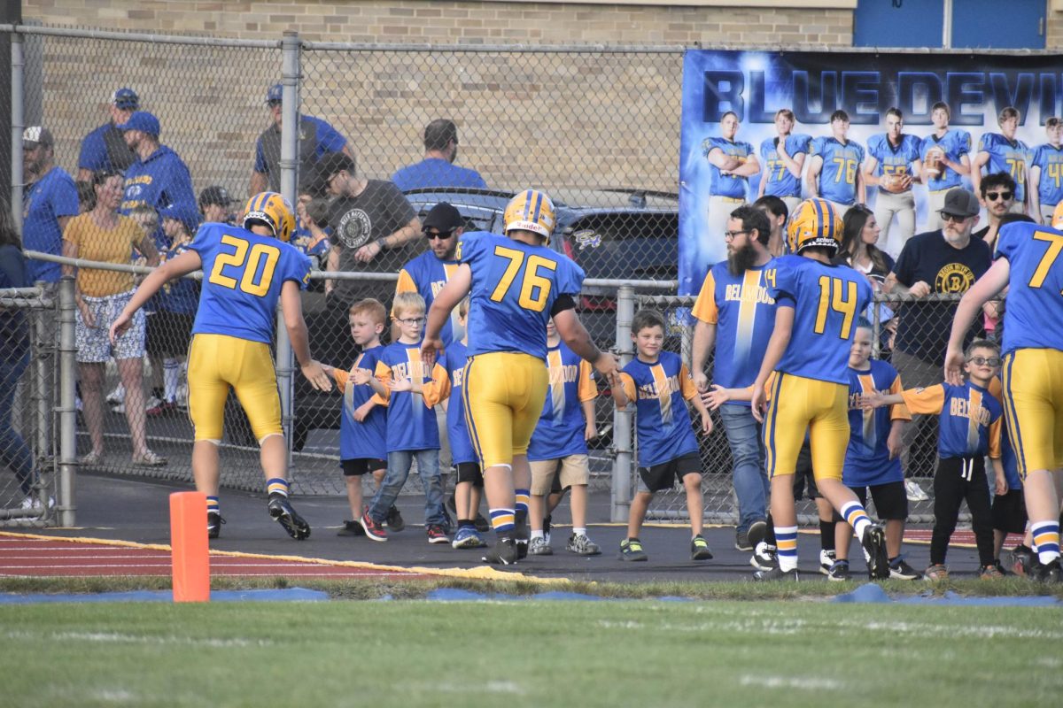 Senior football players high-fiving the Blue Devil youth football players