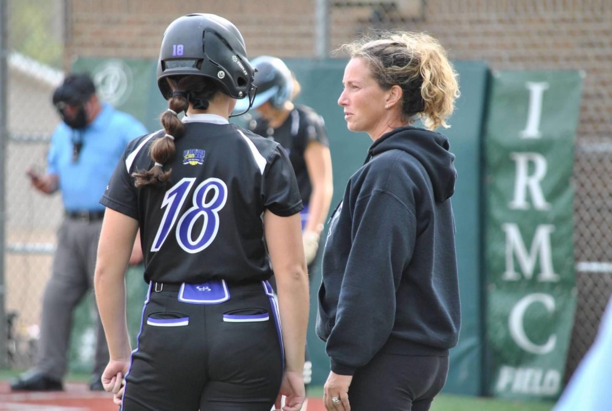 Mrs. Ali Stinson gives some advice to her daughter Lainey at a softball tournament. Mrs. Stinson is the coach of Sideline Cancer, a top-level travel team that plays for something more than just softball.