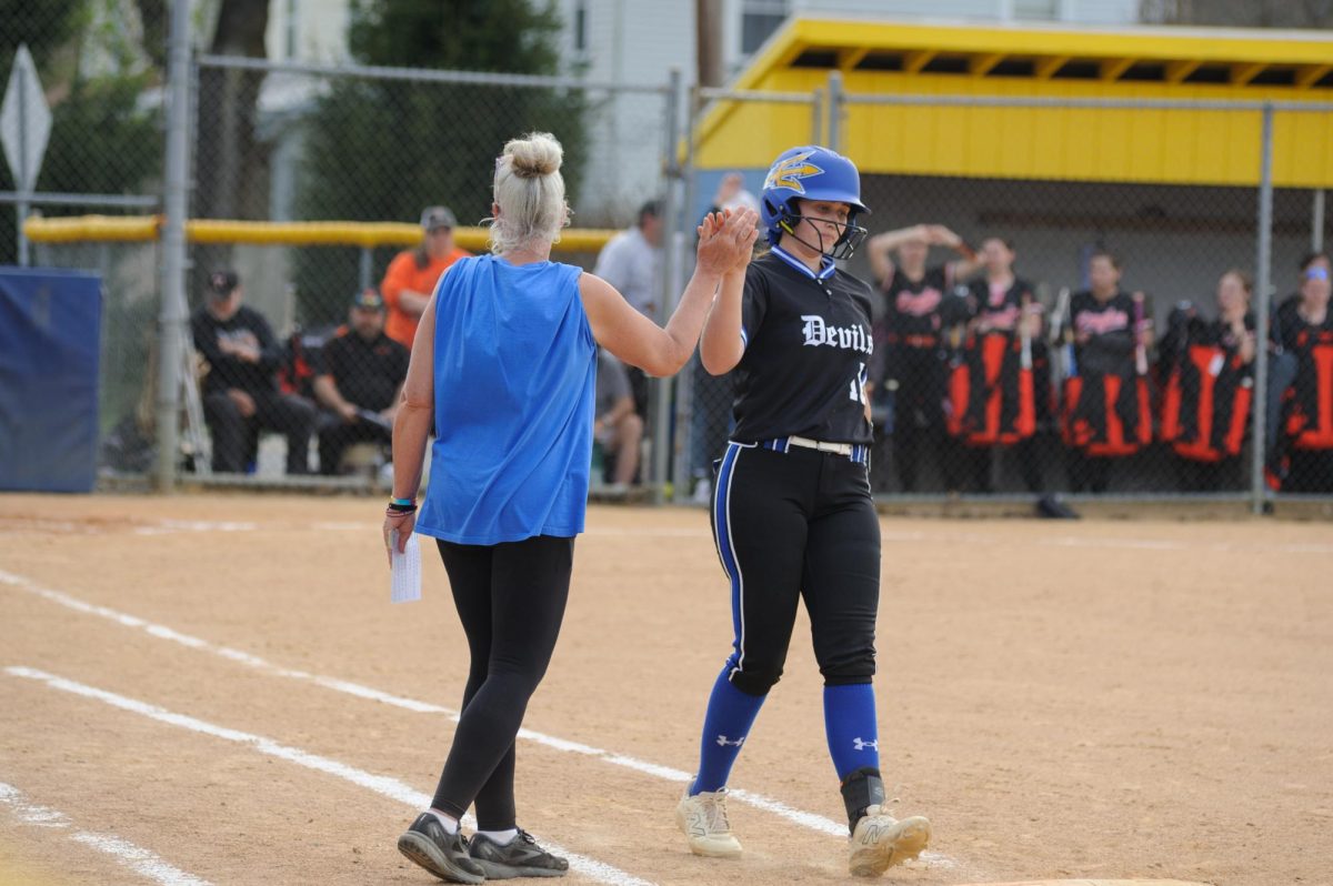Coach Johnsonbaugh gives a high five to Laney Stinson at first.